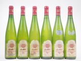 six bouteilles de vin sont alignées sur une surface blanche