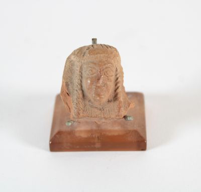 une photo d'une petite statue représentant une femme, posée sur un socle en bois