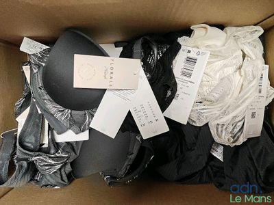 une boîte en carton remplie de nombreux vêtements et d'un chapeau