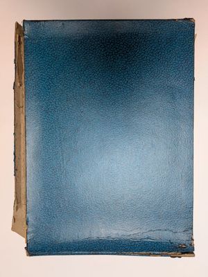 un livre bleu posé sur une table blanche