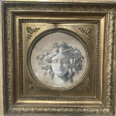 un tableau représentant le visage d'une femme, dans un cadre doré