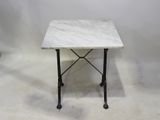 une photo d'une table en marbre avec des pieds en fer et un plateau en marbre blanc