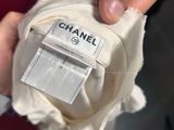 someone is holding a chanel label on a white dress