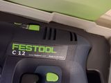 a close up of a green and black electric tool in a box