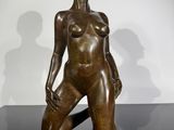 bronze sculpture of a woman sitting on a black surface