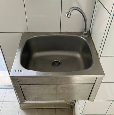 a stainless steel sink with a faucet in the corner