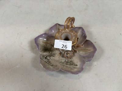 une figurine représentant une fleur, à laquelle est accrochée une étiquette