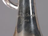 a silver vase that has a handle on it