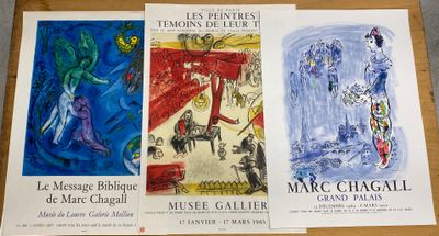trois affiches représentant des tableaux, posées sur une table au plateau en bois