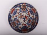 a blue and white plate with red flowers on it
