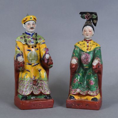 pair of chinese figurines of a man and a woman sitting on a chair