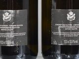 two bottles of wine sitting next to each other on a table