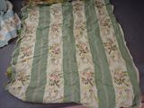 a green and white striped quilt with flowers on it
