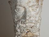 sculpture représentant la tête d'un homme barbu posée sur une table