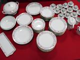 a red table with a bunch of plates and cups on it