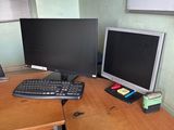a desk with two computer monitors and a keyboard on it