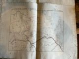 an old book with a map on it sitting on a table