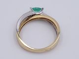 a close up of a ring with a green stone on it