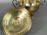 pair of silver plated bowls with handles and handles on a gray surface