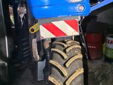 a blue tractor with a red stripe on the front of it