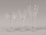 three clear wine glasses sitting on top of a white table