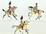 four figurines of people riding horses on a white surface