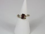 a close up of a ring with a red stone on it