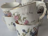 three cups and a saucer are sitting on a table