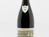 une bouteille de vin rouge posée sur une table blanche