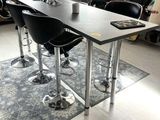 a table with four chairs and a rug in a room