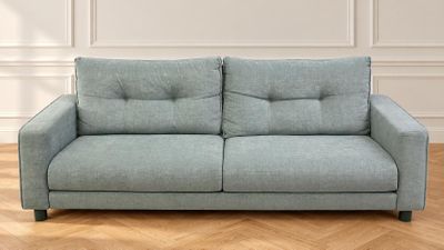 an image of a blue couch sitting on top of a hard wood floor