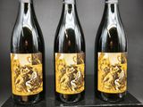 trois bouteilles de vin posées sur un bloc de bois