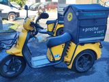 a yellow scooter with a box on the back of it