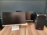 two computer monitors sitting on top of a wooden desk next to each other