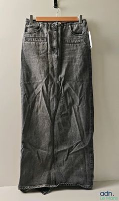 une jupe en jean gris suspendue à un cintre devant un mur blanc