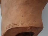 a clay vase with writing on it sitting on a table