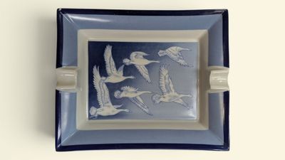 une assiette bleue et blanche sur laquelle est représenté un motif d'oiseaux