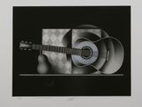 a black and white photo of a guitar on a table