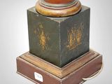 a green vase sitting on top of a wooden stand