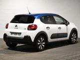 the rear of a white and blue citrole car parked in a garage