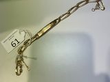 un bracelet en or auquel est attachée une chaîne