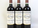 trois bouteilles de vin rouge posées l'une à côté de l'autre sur une surface blanche
