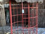 une cage rouge au toit de chaume, dans une grange