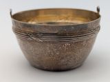an old metal bowl sitting on top of a white surface