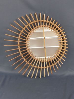 un miroir fixé au mur, fait de tiges de bambou