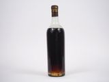 une bouteille d'alcool posée sur une surface blanche