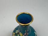 a blue vase with a gold rim sitting on a table