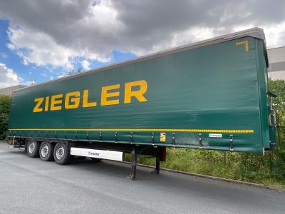 a green semi truck that is parked on the side of the road
