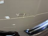 the front end of a white car with a sticker on it ' s hood