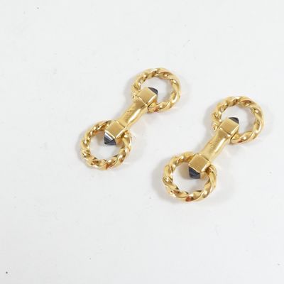 deux paires de boucles d'oreilles dorées ornées de pierres noires sur fond blanc
